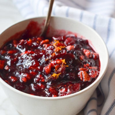 Spoon in a bowl of cranberry pecan relish.