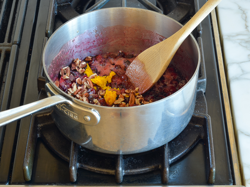 adding pecans and orange zest to cranberry maple mixture