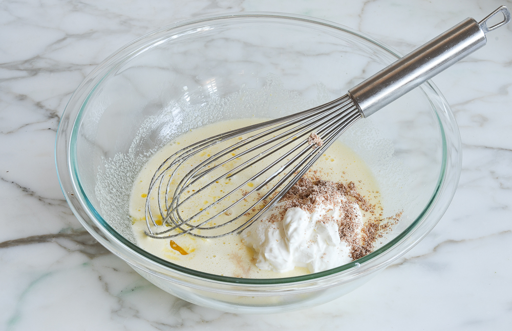 adding sour cream, butter, nutmeg and vanilla to mixing bowl