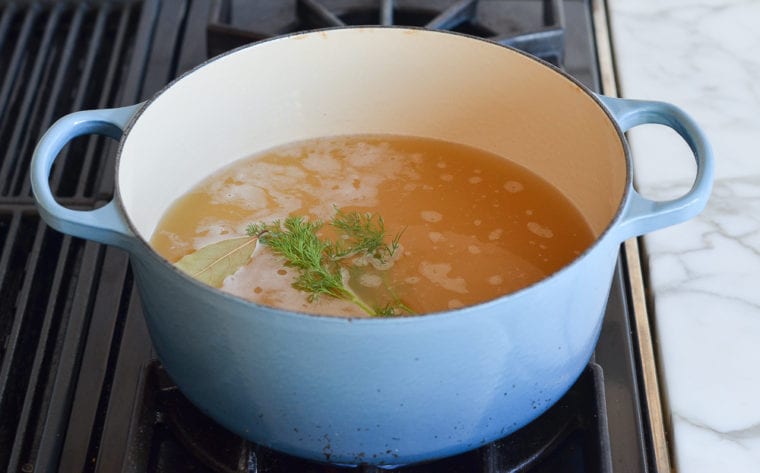 bringing the chicken broth and rice to a boil
