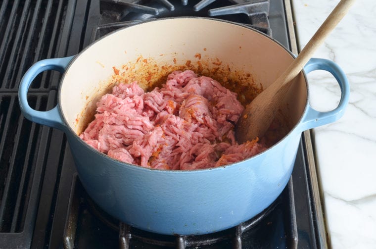 adding part of the turkey to the pot.