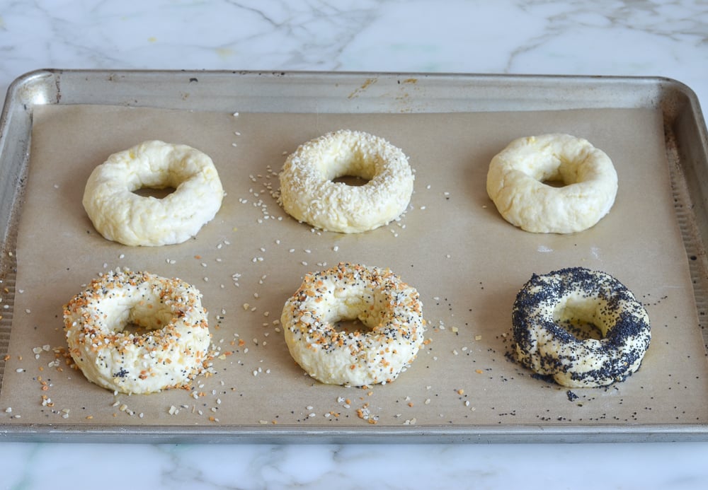sprinkling toppings on bagels