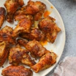 Crispy baked chicken wings on plate.