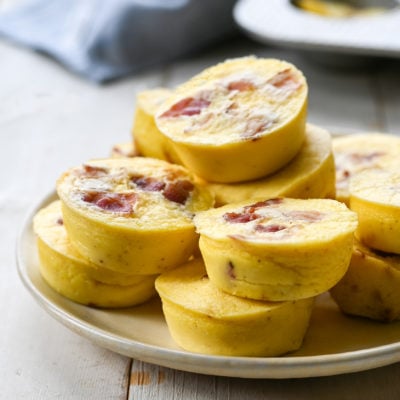 Egg bites with bacon and gruyere piled on a plate.