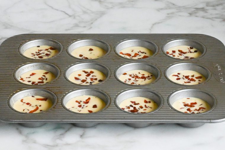egg bite batter with bacon in muffin pan
