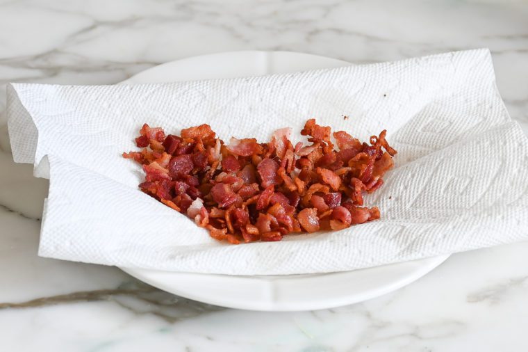 bacon draining on paper towel-lined plate