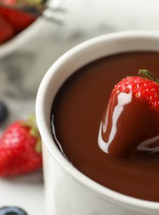 dipping strawberry into chocolate fondue