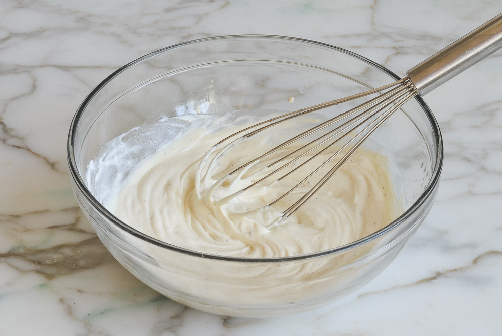 Sour cream, mayonnaise, and seasoning whisked in bowl.