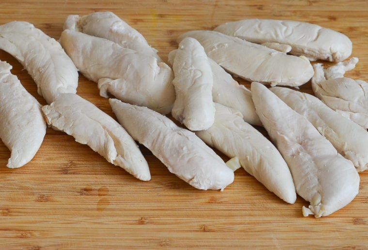 poached chicken tenderloins on cutting board