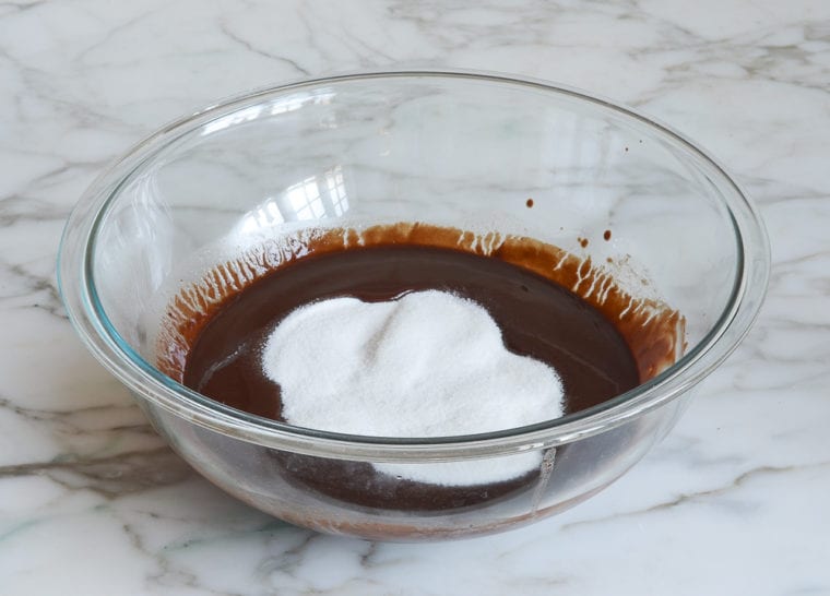 adding granulated sugar to chocolate mixture