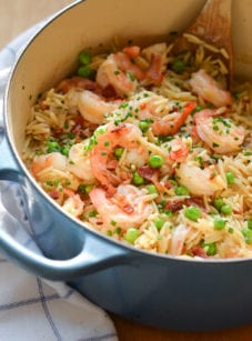 Orzo risotto with shrimp, peas, and bacon in a Dutch oven.