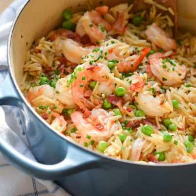 Orzo risotto with shrimp, peas, and bacon in a Dutch oven.