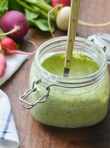 Glass jar of green goddess dressing.