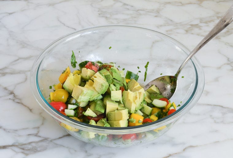 adding the avocados to the salad