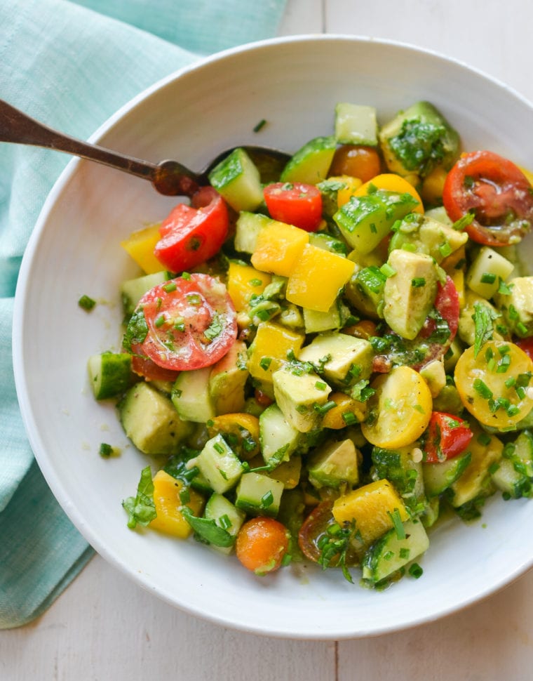 Spoon in a bowl with a summer avocado salad.