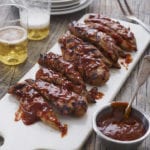 Grilled barbeque chicken on a cutting board.