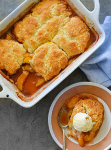 Peach cobbler in a baking dish and on a plate.