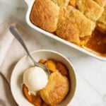 peach cobbler in a bowl with ice cream