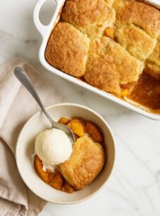 peach cobbler in a bowl with ice cream