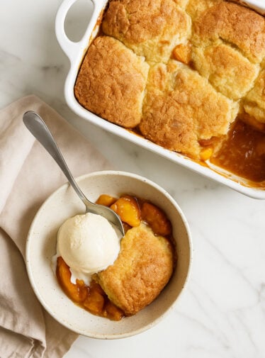peach cobbler in a bowl with ice cream