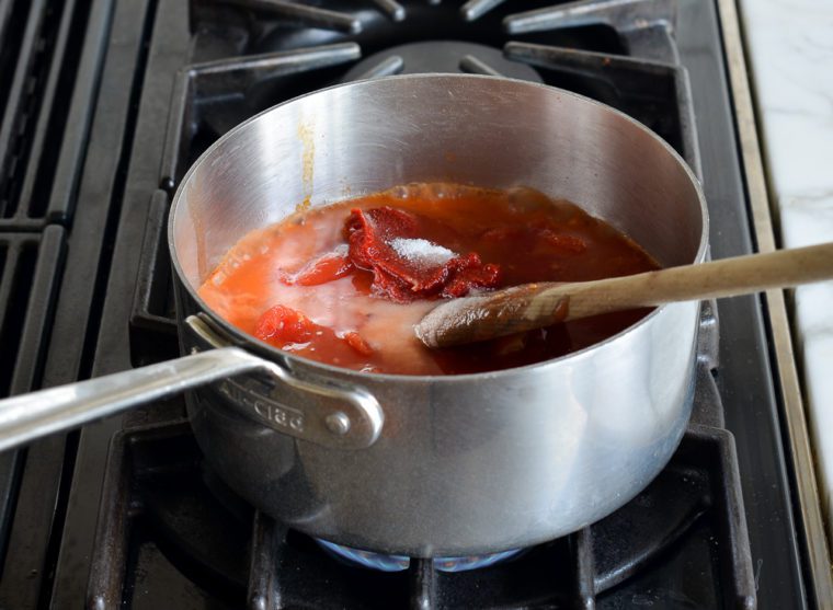 adding tomatoes, tomato paste, vodka, and seasoning