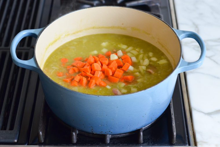 adding the carrots and celery to the split pea soup