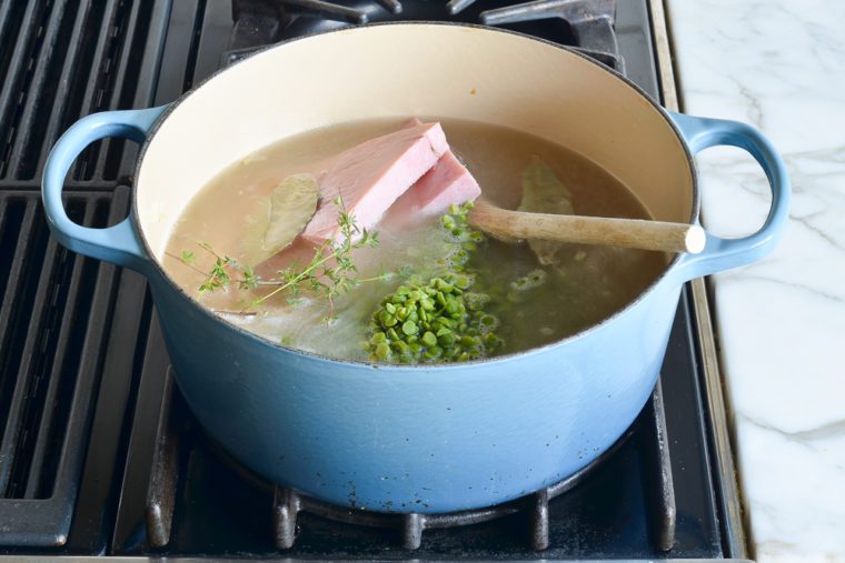 broth, water, ham, bacon, split peas, and herbs added to the pot