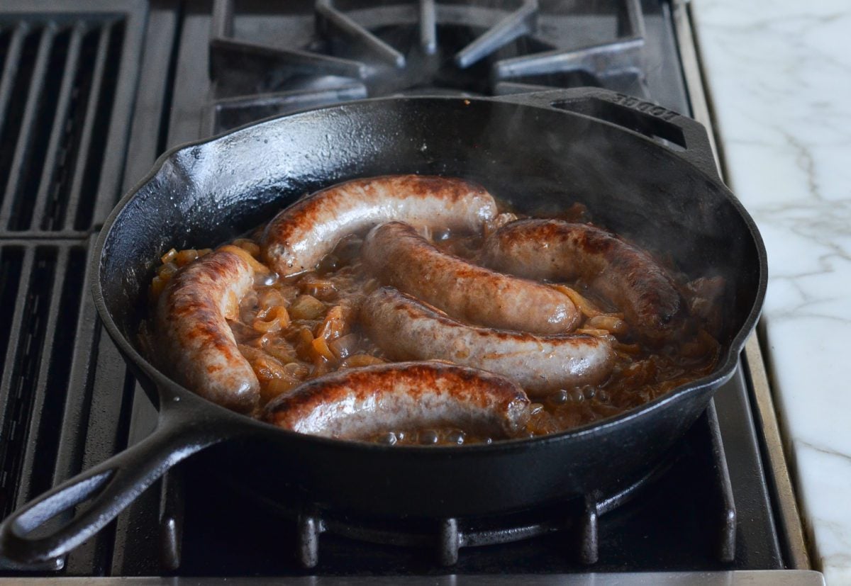 Finished bratwurst and onions in skillet.