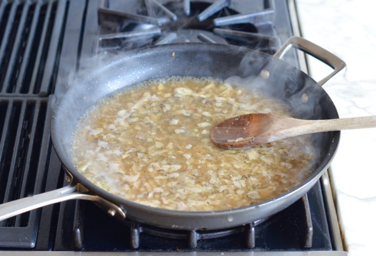 adding chicken broth and apple cider to skillet
