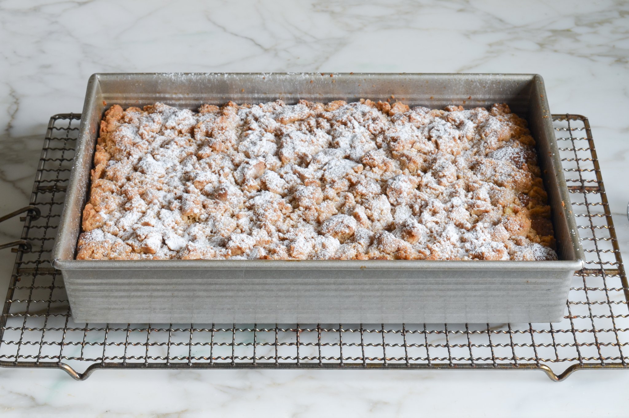 Crumb cake dusted with confectioners sugar.