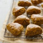Pumpkin scones with spiced pumpkin glaze on a wire rack.
