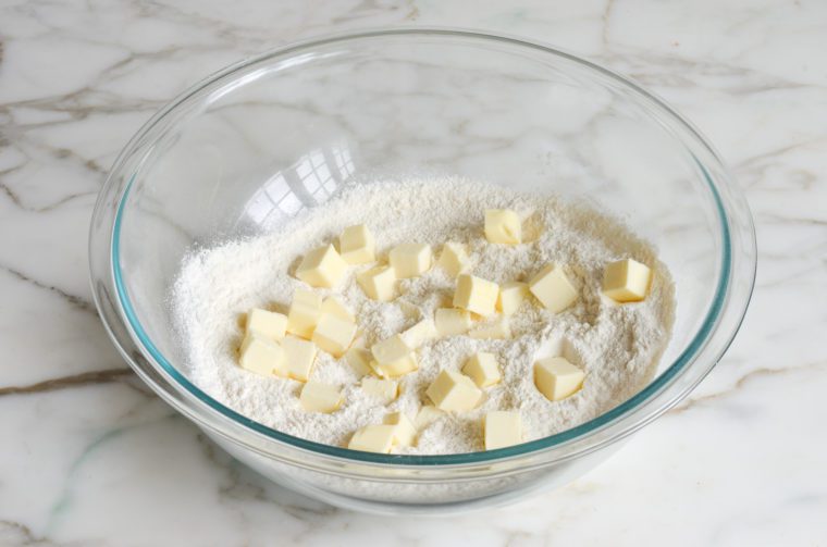 adding cubes of butter to dry ingredients