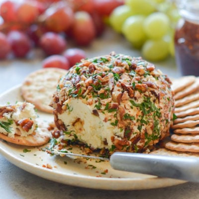 Cheese ball on a plate with crackers.