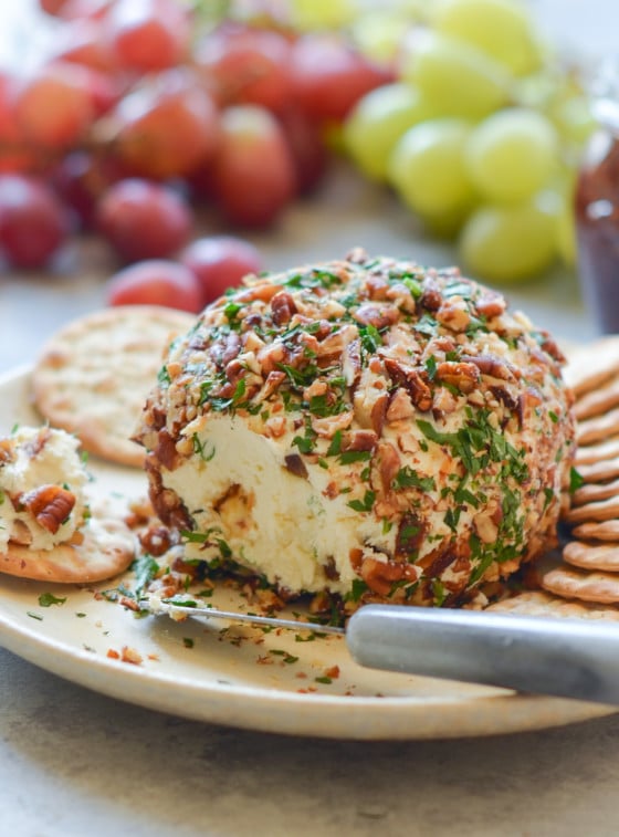Cheese ball on a plate with crackers.