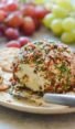 cheese ball on platter with crackers and grapes