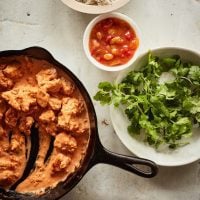 Mostly-served skillet of butter chicken.