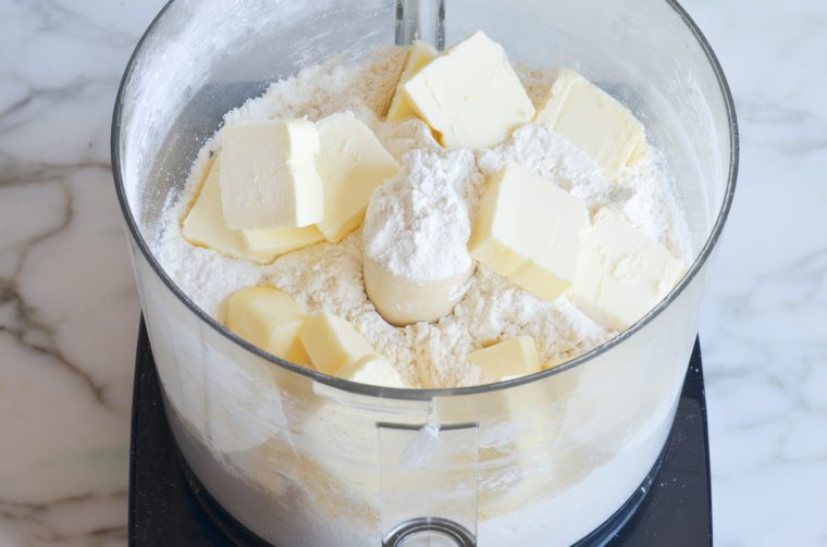 adding flour, butter and salt to food processor