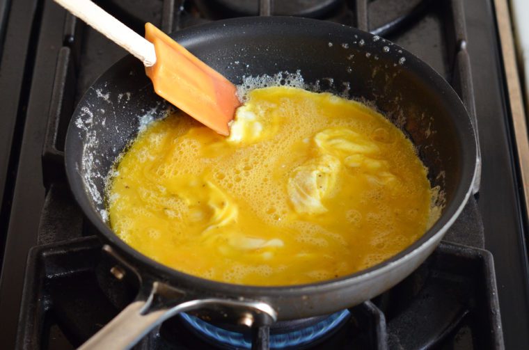scrambling the eggs with a rubber spatula