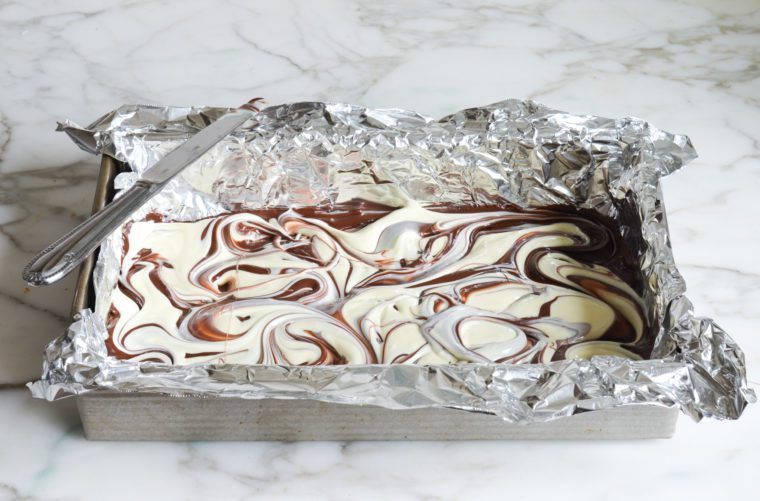 swirling the two chocolates with a knife to make marbled peppermint bark