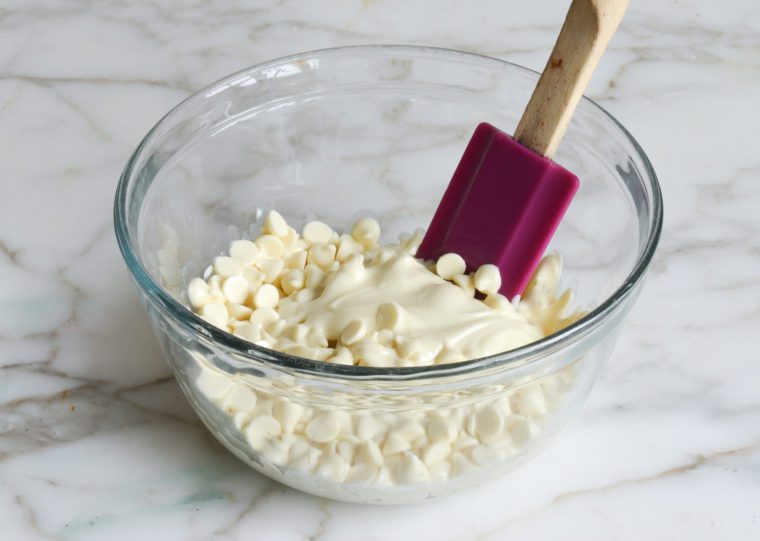 softened white chocolate chips in bowl