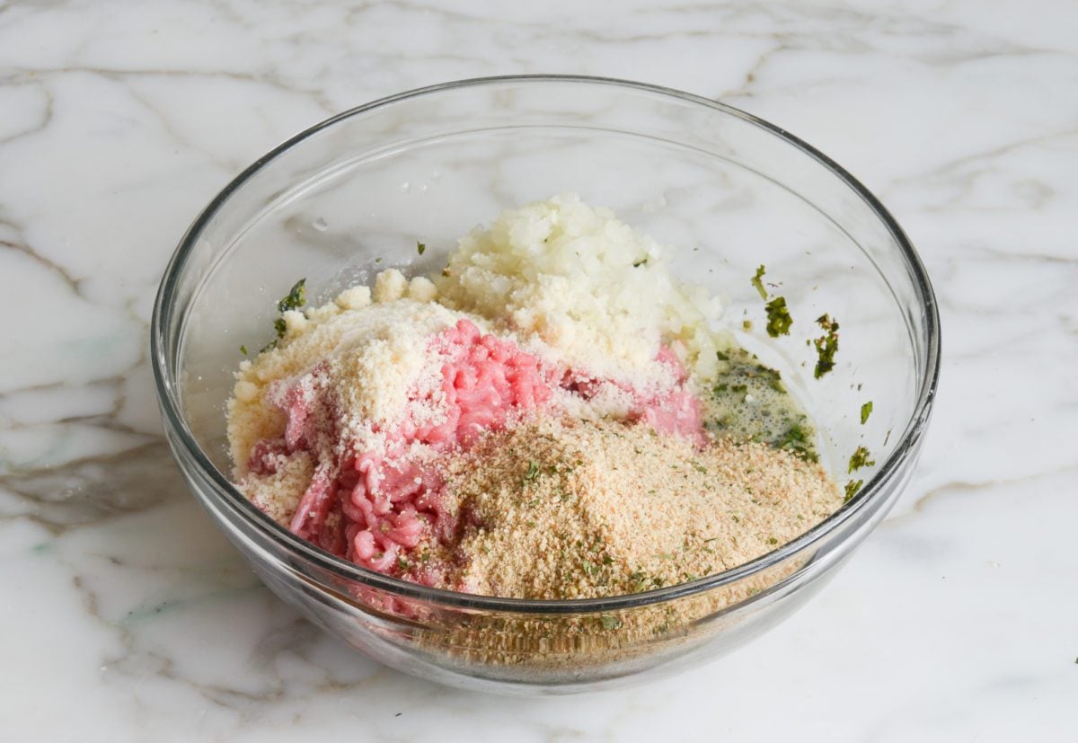 adding ground turkey, onion, cheese, and breadcrumbs to egg mixture