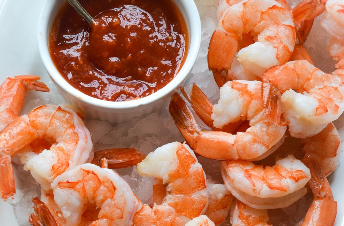 shrimp cocktail and cocktail sauce on a plate over ice.