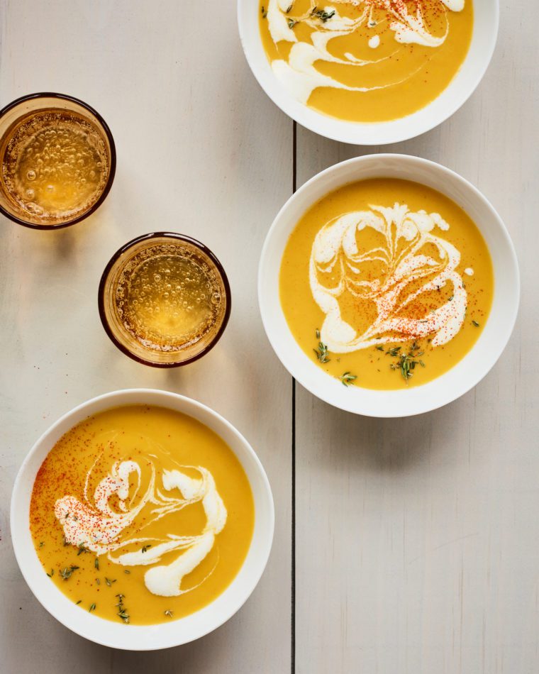 Bowls of pumpkin soup on a table.