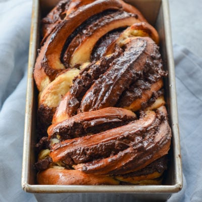 Loaf of chocolate babka in a bread pan.
