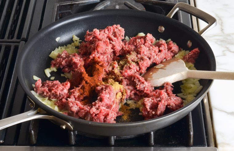 adding beef and spices to skillet