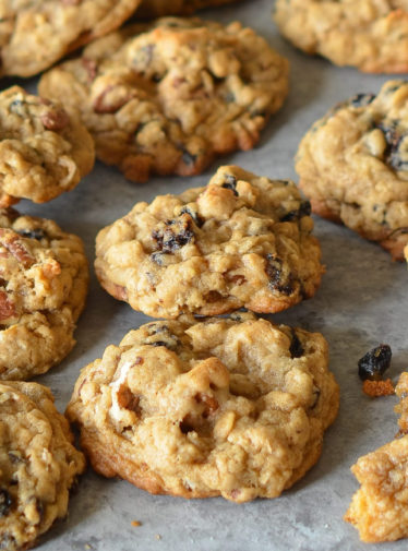 Oatmeal cookies with raisins and pecans on parchment paper.