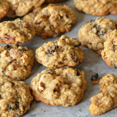 Oatmeal cookies with raisins and pecans on parchment paper.