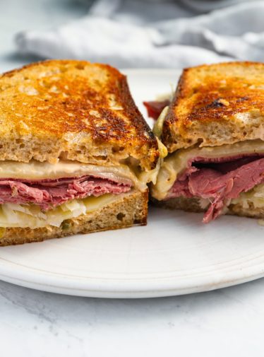 reuben sandwich on plate with pickle