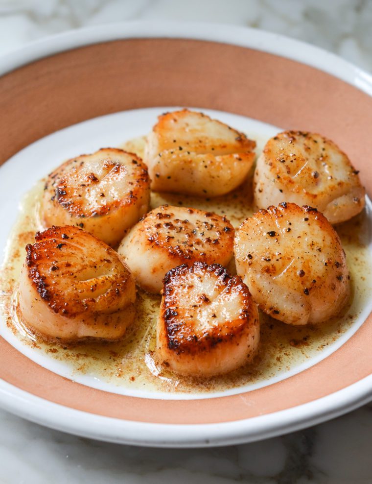 Plate of pan-seared scallops with lemon butter.