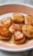 Plate of pan-seared scallops with lemon butter.